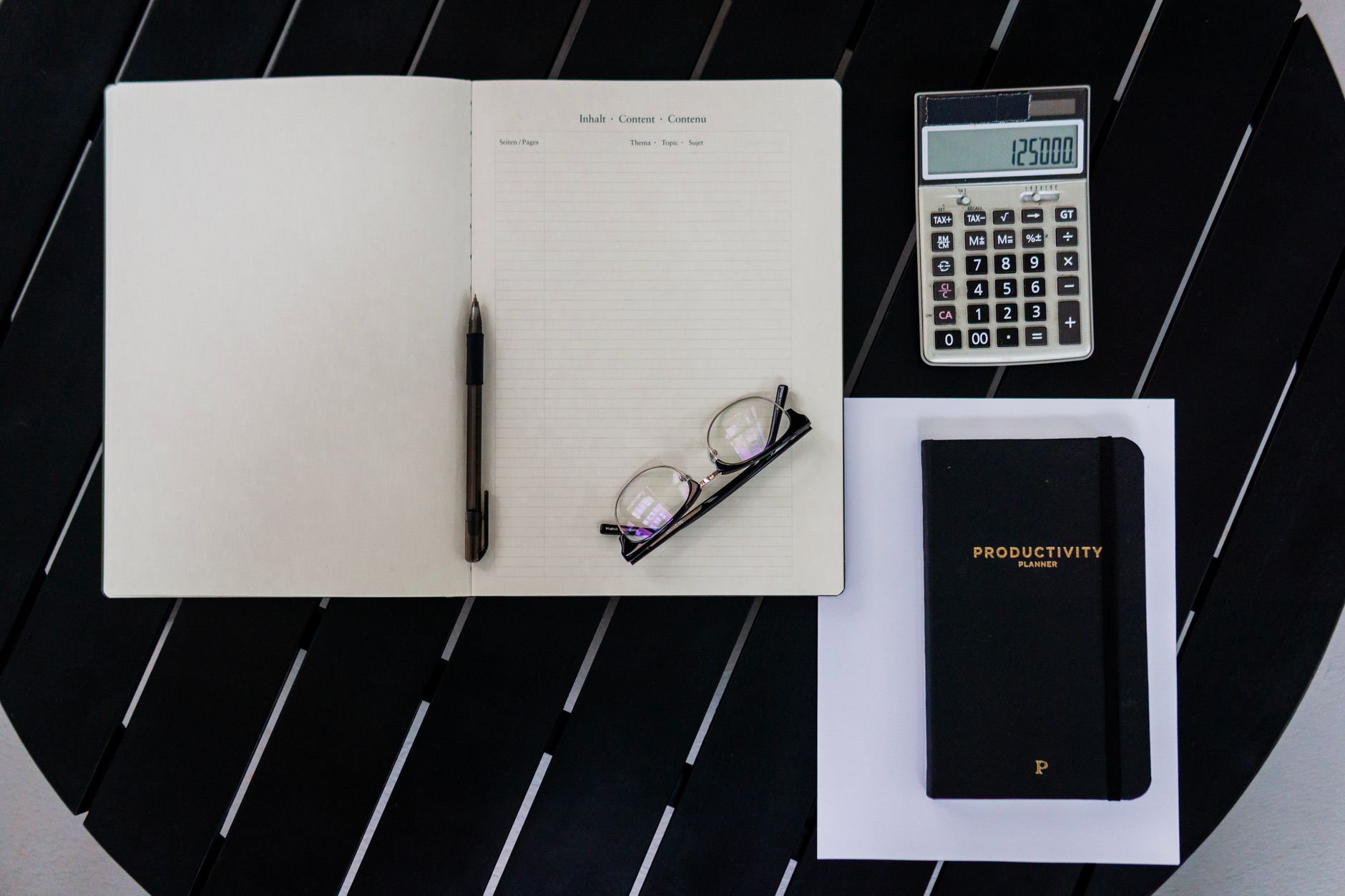 Weekly planner and calculator on a desk