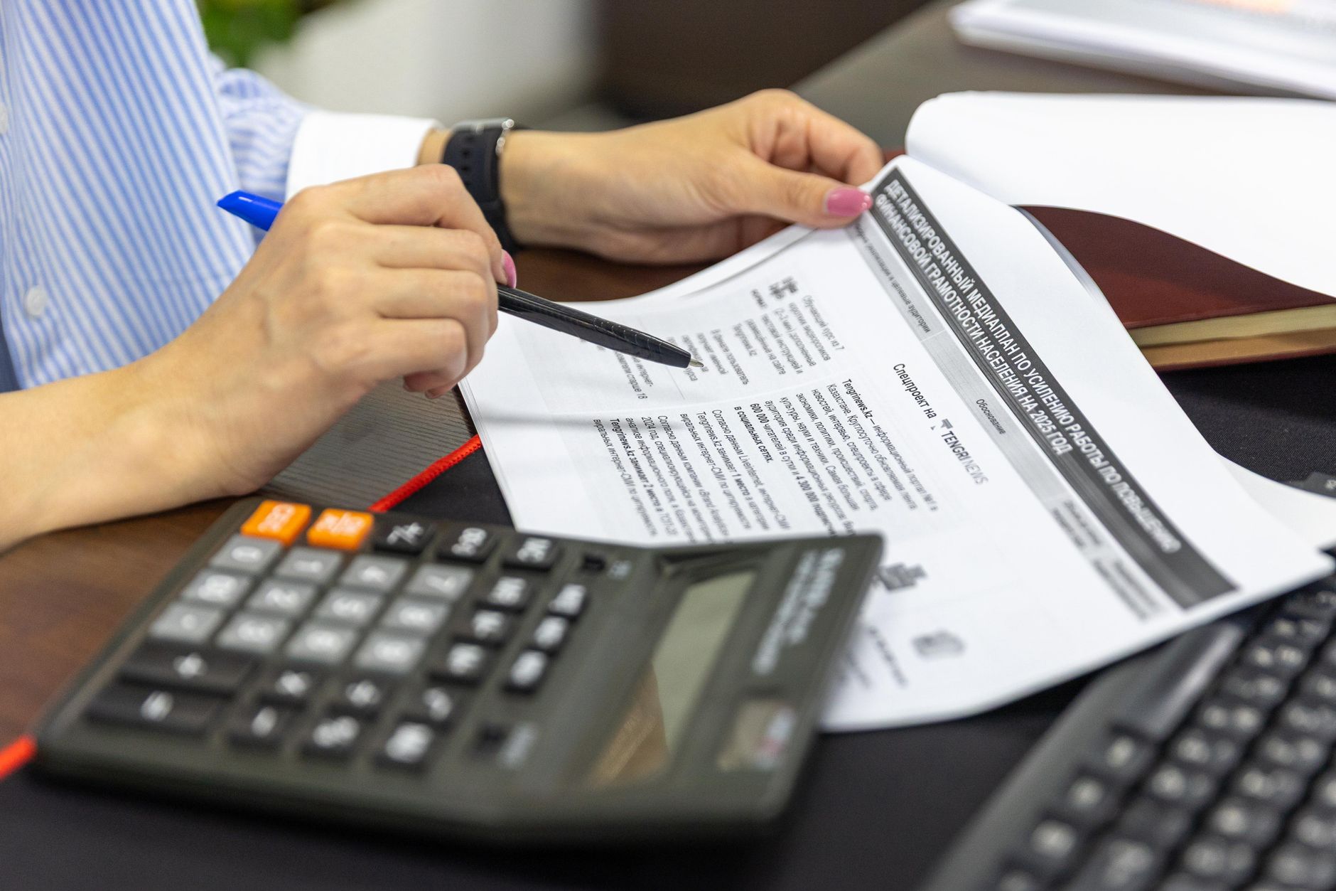 Financial statement with a calculator and pen